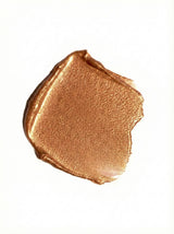 Bronze-colored makeup swatch on a white background